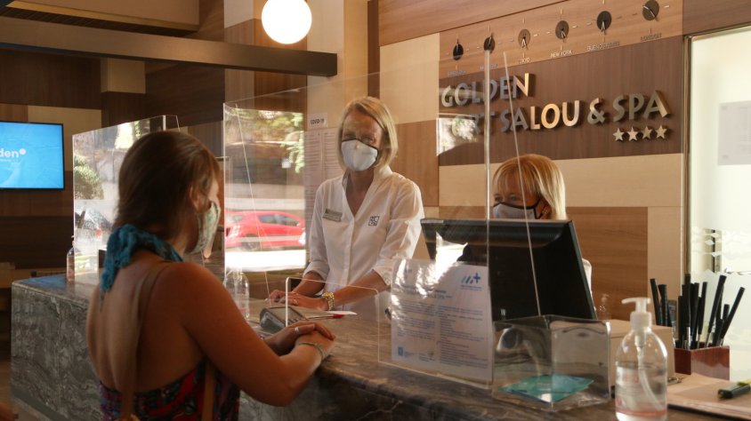Pla tancat d'una turista i dues treballadores a la recepció de l'Hotel Golden Port Salou. Imatge del 13 de setembre del 2020