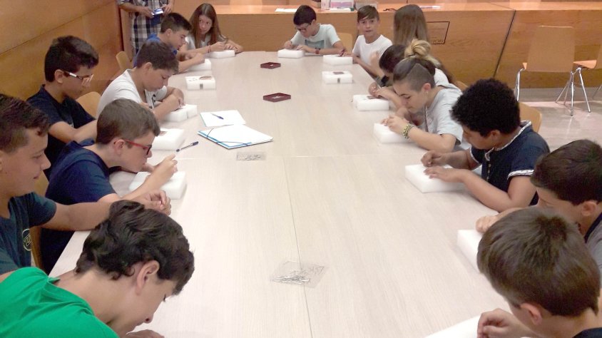 Els alumnes del Col·legi Residència picant un patró de punta al coixí.