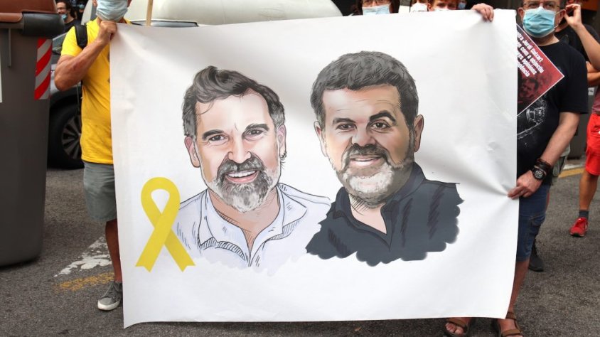 Pla curt d’una pancarta a l’acció convocada per Òmnium i l’ANC davant la delegació del govern espanyol a Barcelona coincidint amb els mil dies de presó de Jordi Cuixart i Jordi Sànchez, el 12 de juliol del 2020