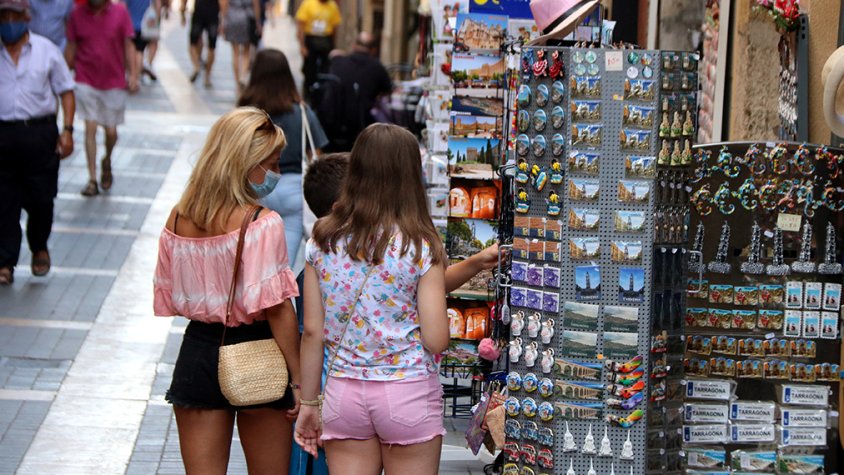 Família de turistes mirant els expositors d'una botiga de records.
