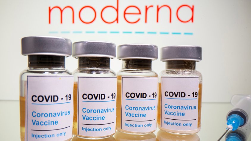 Vials amb un adhesiu que diu "COVID-19 / Vacuna contra el coronavirus / només per injecció" i una xeringa davant del logotip de Moderna.