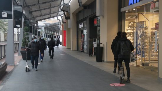 Pla obert de diverses persones passejant per l'interior del centre comercial La Maquinista durant el primer dia de reobertura. Imatge del 14 de desembre de 2020.